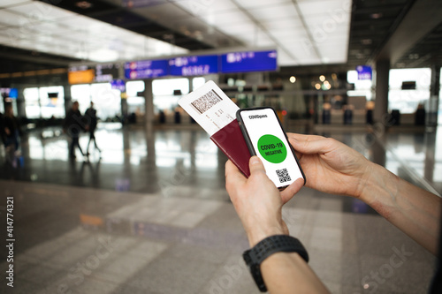 Wallpaper Mural Digital vaccine passport. Hand holding mobile COVID-19 app for vaccination. Covid pass for traveling. Travel concept. Phone in airport and airplane in the background. Passport and flight tickets Torontodigital.ca