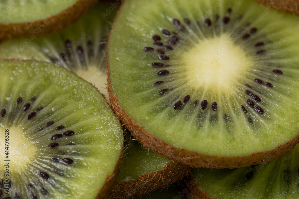 Background with sliced juicy kiwi with black seeds Background with sliced juicy kiwi with black seeds