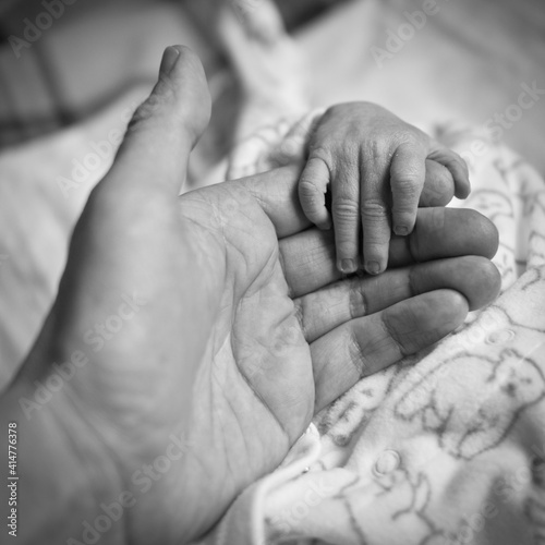 The man is holding a small child's hand. Black and white photo.
