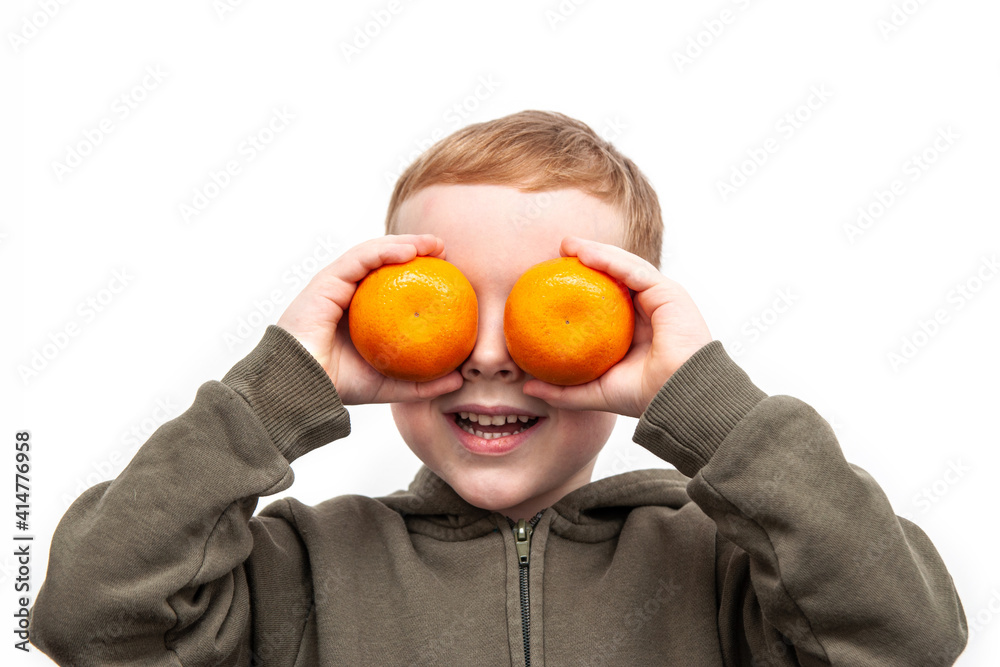 Funny red haired boy with oranges on eyes. Dressed green hoodie. isolated on white. Funny red haired boy with oranges on eyes. Dressed green hoodie. isolated on white.