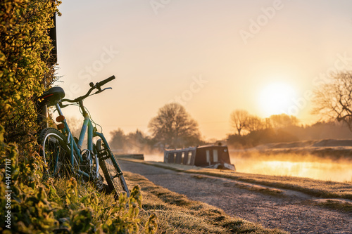Photos Canal boat with mountain bike left leaning against hedge row early morning sunri