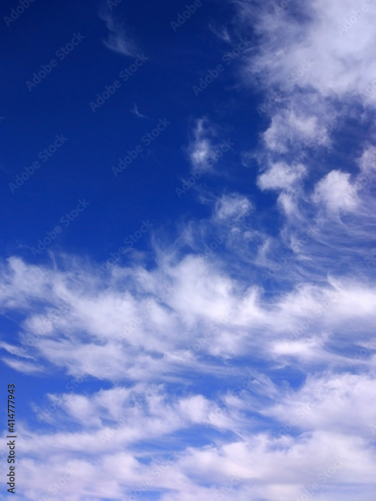 dark blue sky with soft white cirrus clouds
