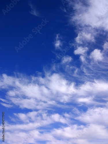 dark blue sky with soft white cirrus clouds
