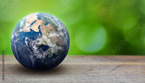 Earth planet sphere on green leaves background. Ecology and environment care concept. Greenpeace and Earth day theme. Elements of this image furnished by NASA photo