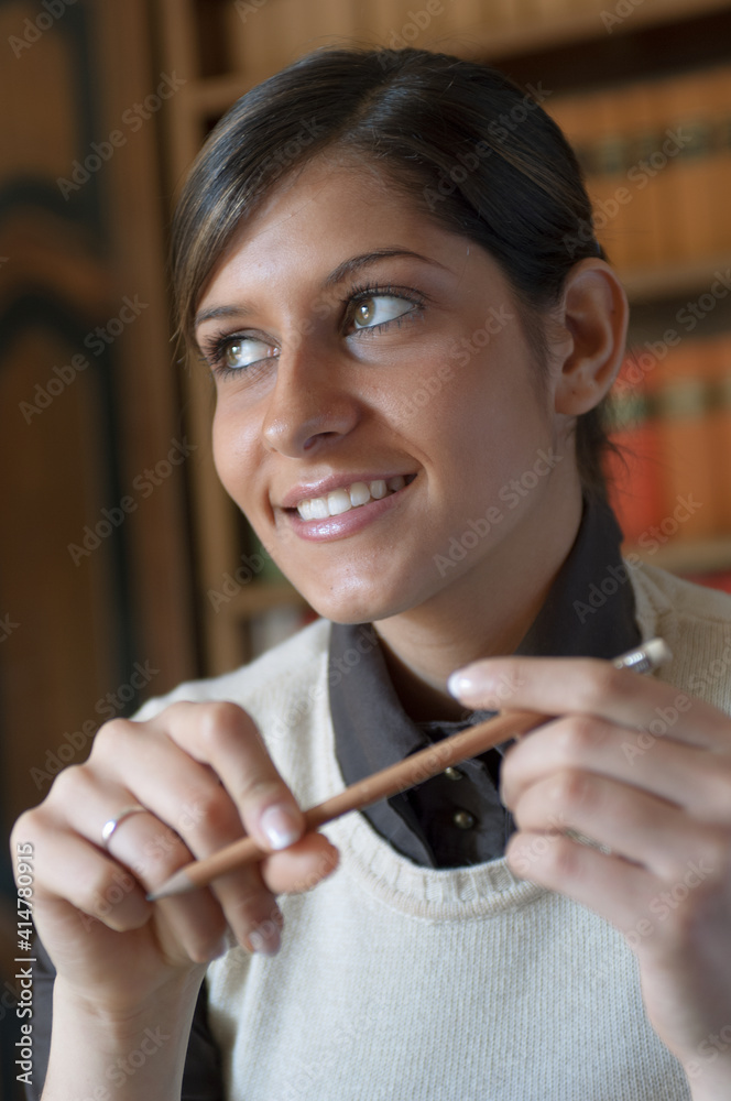 Ragazza sorridente tiene in mano una matita Ragazza sorridente tiene in mano una matita