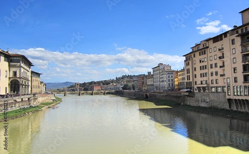 View of the Arno River in Florence  Italy. Yellow water. A bridge in the distance  buildings on the sides 
