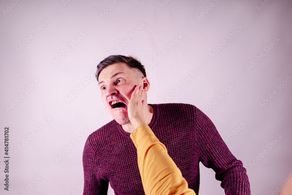 Foto de Crop person slapping scared man in face. Emotional male getting  slapped in face while shouting with closed eyes in fear on white background  do Stock | Adobe Stock