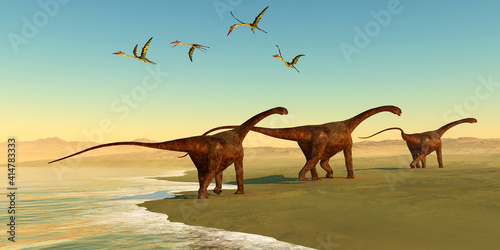 Malawisaurus Dinosaur Beach - Quetzalcoatlus reptiles fly out to sea as a herd of Malawisaurus dinosaurs go in search of vegetation to eat. photo