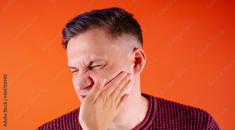 Crop person slapping scared man in face. Emotional male getting slapped in face while shouting with closed eyes in fear on orange background Crop person slapping scared man in face. Emotional male getting slapped in face while shouting with closed eyes in fear on orange background