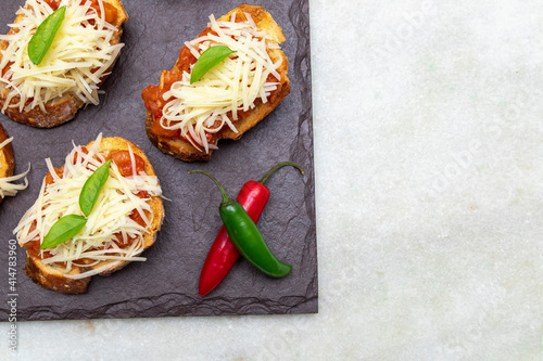 bruschetta toasts with cherry tomatoes, mozzarella and basil. Top view with space for your text