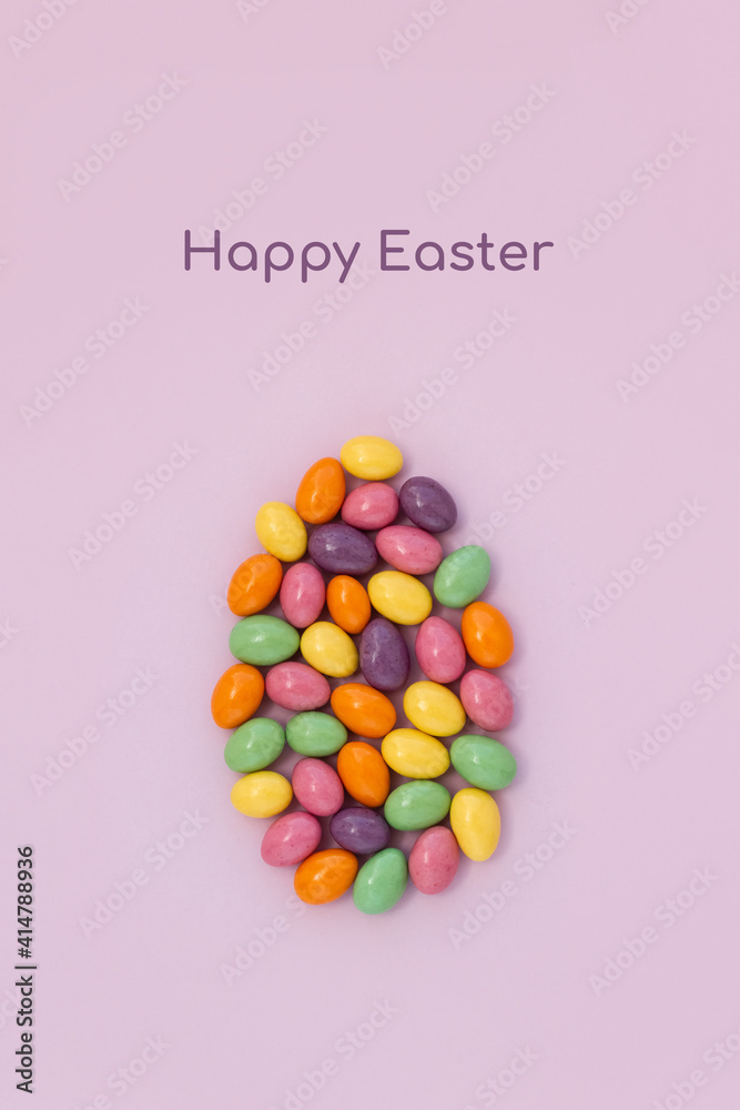 Phrase Happy Easter and large egg made from colored chocolate eggs. Minimal holiday concept. Vertical card, copy space Phrase Happy Easter and large egg made from colored chocolate eggs. Minimal holiday concept. Vertical card, copy space