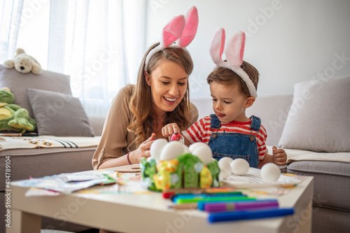 Ester day is coming. Family preparing for Easter. They are happy and positive, enjoying their time together, and proudly showing the colorful eggs. Easter holiday concept.