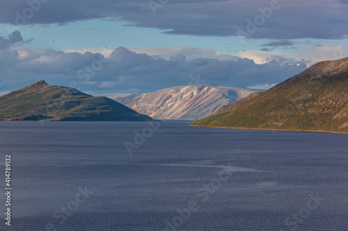 Impressive view of calm waters of the Laksefjord in an environment of majestic mountains, Finnmark in the northern Norway.