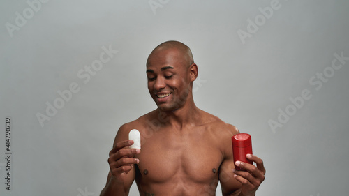 Male turning to an alum deodorant stick with glad expression