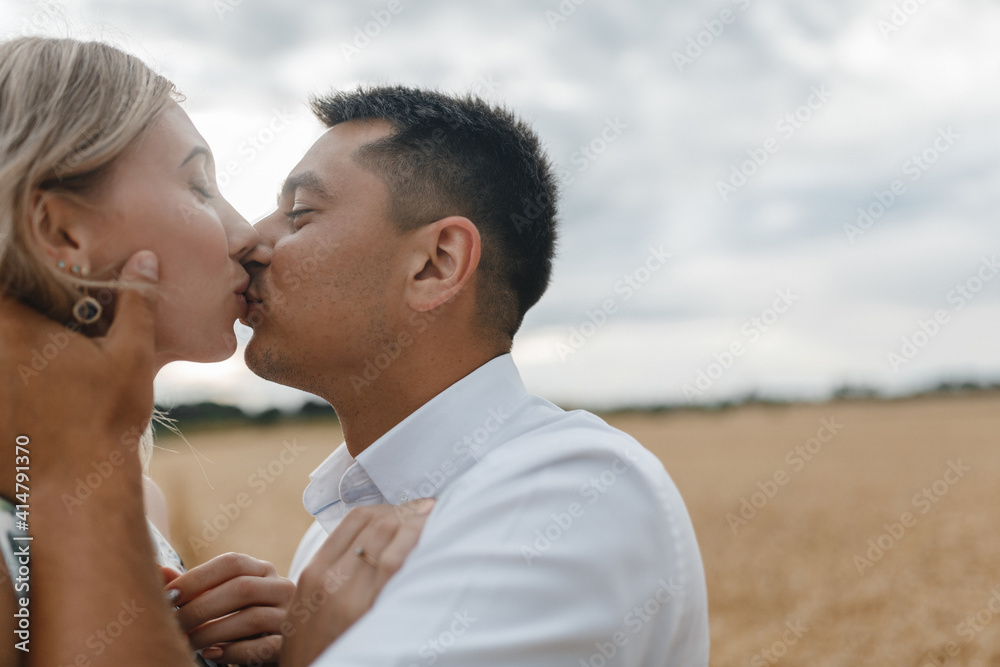 Copule kissing in the background of sky and wheat field. Lovers in the wheat field with place for your text