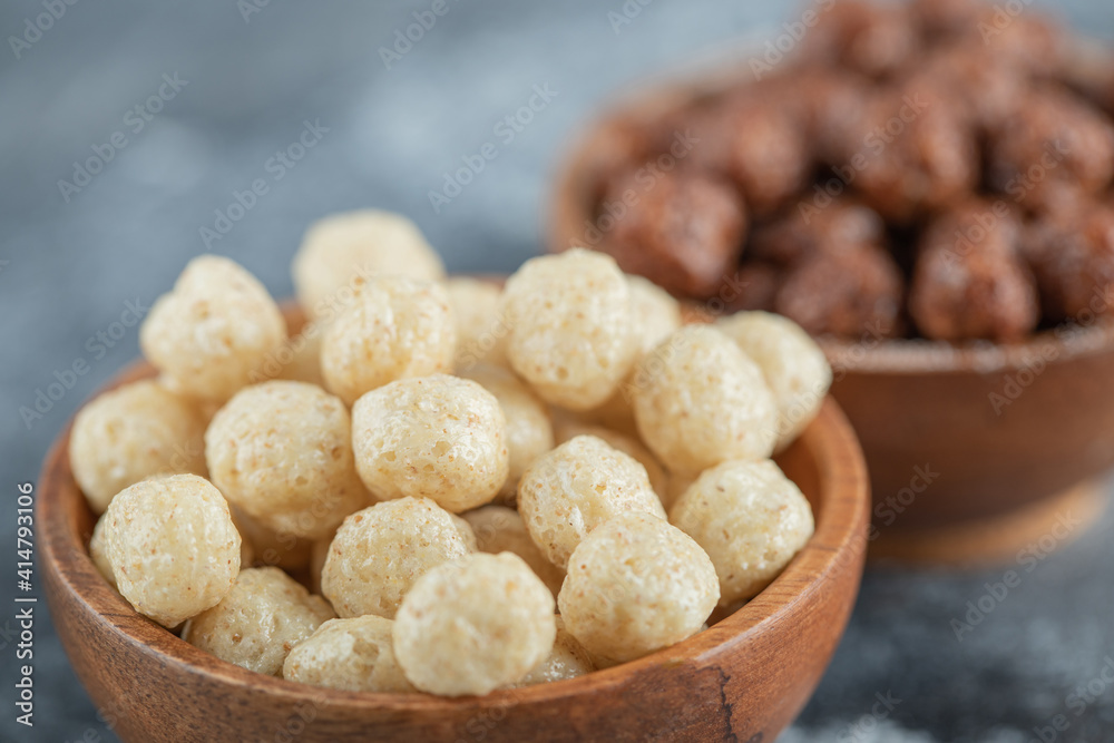 Wooden bowls with sweet corn balls on a gray background Wooden bowls with sweet corn balls on a gray background