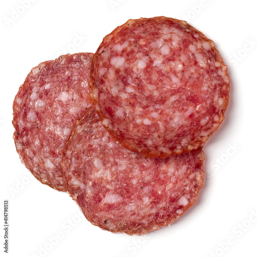 Slices of salami isolated on white background closeup. Sausage top view.