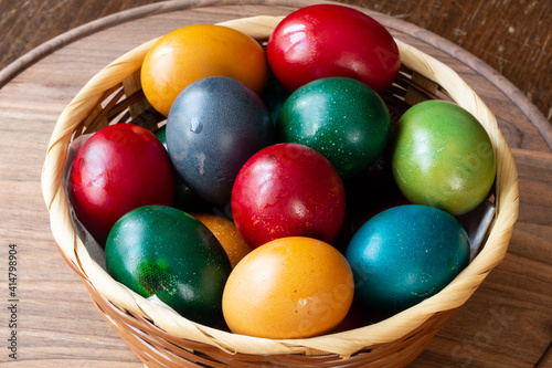 Easter eggs and Easter bun with flowers - wood background