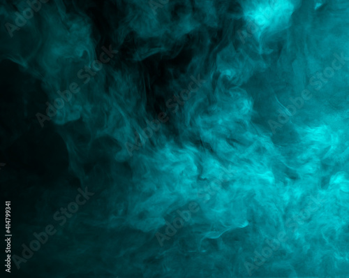 Abstract background of chaotically mixing clouds of turquoise smoke on a background of darkness