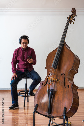 Man with his phone. There is a double bass White background
