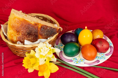 Easter eggs and Easter bun with flowers - red background photo