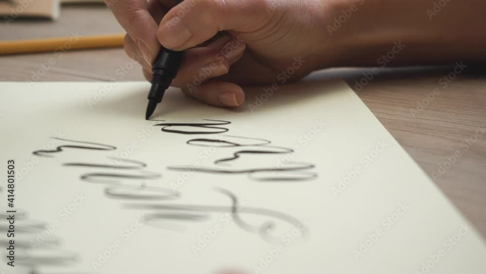 Female Hand is Writing Follow your Dreams in Calligraphic Form / Close Up Female Hand is Writing Follow your Dreams in Calligraphic Form / Close Up