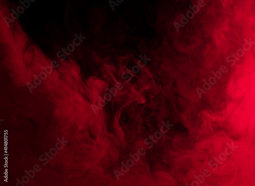 Abstract background of chaotically mixing puffs of red smoke on a dark background