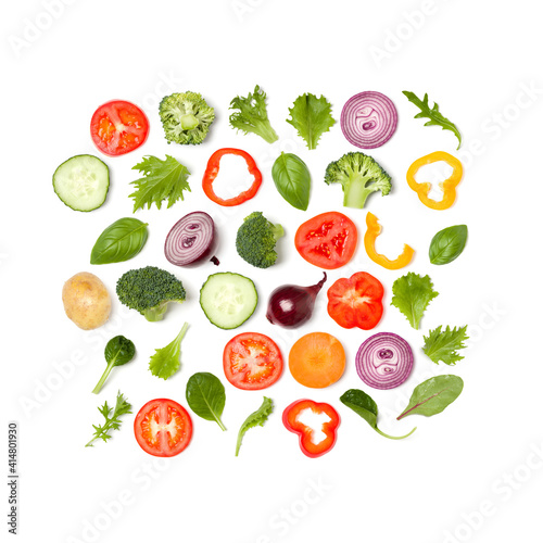 Creative layout made of tomato slice, onion, cucumber, basil leaves. Flat lay, top view. Food concept. Vegetables isolated on white background. Food ingredient pattern.