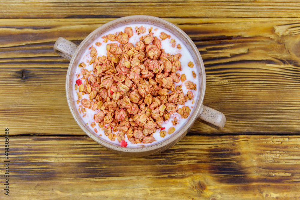 Granola with milk in bowl on wooden table. Top view. Healthy breakfast concept Granola with milk in bowl on wooden table. Top view. Healthy breakfast concept