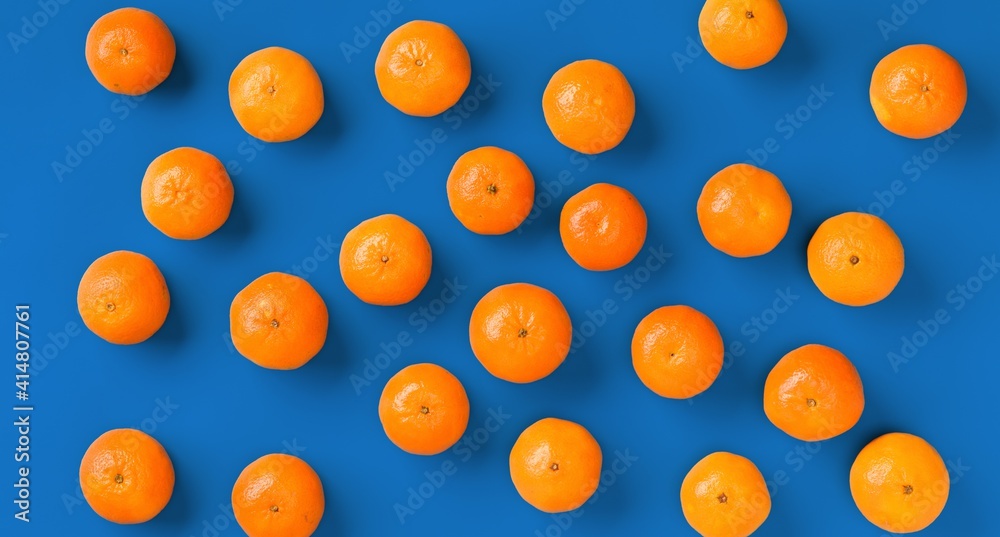 Fruit pattern of fresh orange tangerine or mandarin over blue background. Flat lay, top view. Pop art design, creative summer concept. Citrus in minimal style. Fruit pattern of fresh orange tangerine or mandarin over blue background. Flat lay, top view. Pop art design, creative summer concept. Citrus in minimal style.