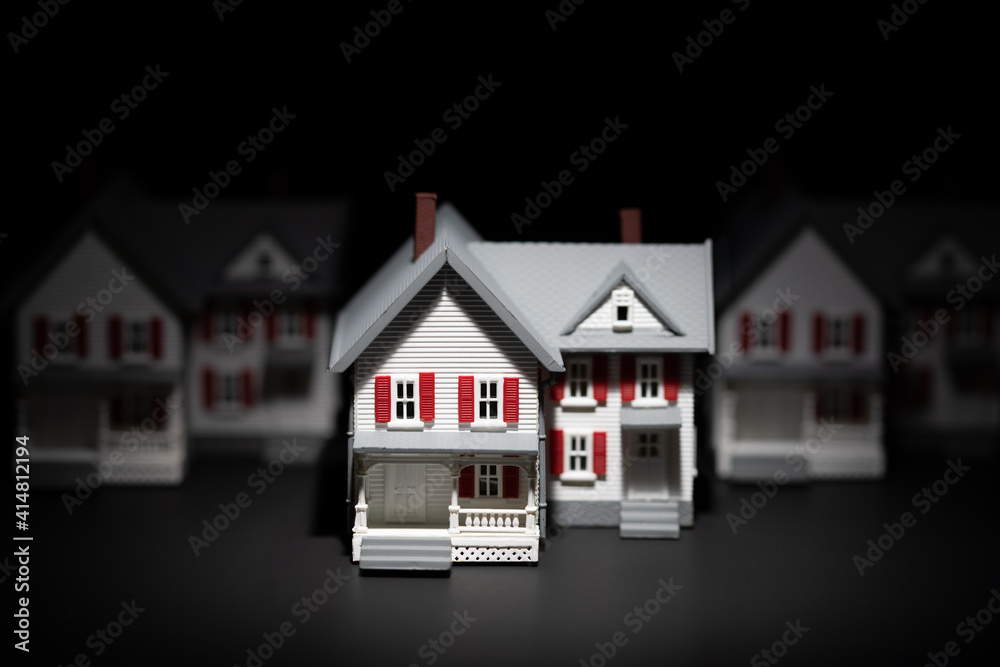 Several Model Houses In A Row With One Spot Lit In The Front Several Model Houses In A Row With One Spot Lit In The Front