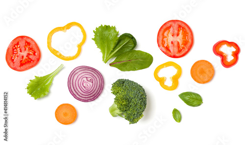 Creative layout made of tomato slice  onion  cucumber  basil leaves. Flat lay  top view. Food concept. Vegetables isolated on white background. Food ingredient pattern.