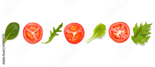 Creative layout made of tomato slices and lettuce salad leaves. Flat lay, top view. Food concept. Vegetables isolated on white background. Food ingredients seamless pattern.