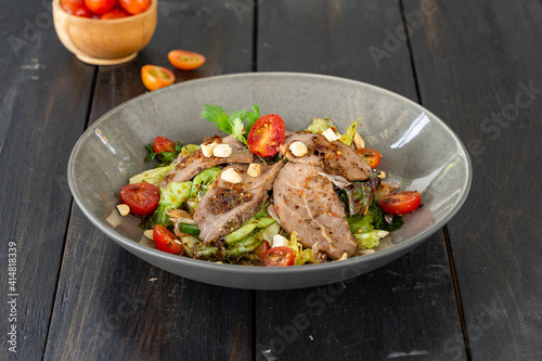 Beef salad with various vegetables served on a ceramic plate.