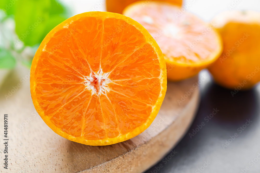 Fresh orange fruit sliced on cutting board with leave and citrus blured. tropical fruit orange breed in thailand. high in vitamin C. suitable for eating to control weight or diet. food for health. Fresh orange fruit sliced on cutting board with leave and citrus blured. tropical fruit orange breed in thailand. high in vitamin C. suitable for eating to control weight or diet. food for health.