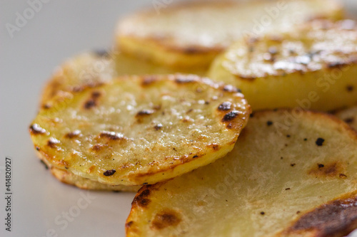 Batata assada fatiada, fatias de batata assadas para refeição, fatias assadas de batata, alimento vegetariano, comida vegana © Mauri