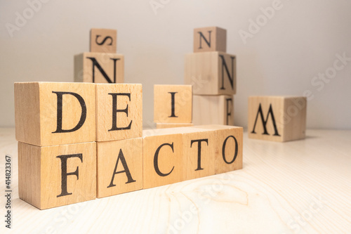 The Defacto Word is from wooden cubes. Terms of state government.