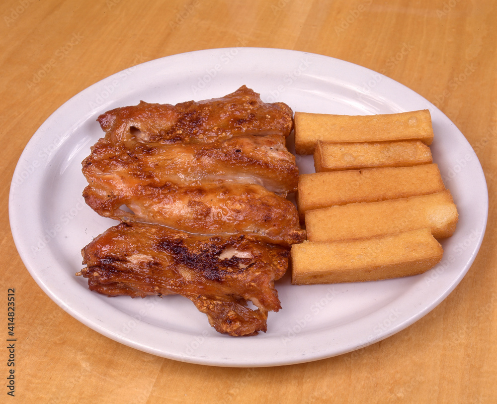 Fried chicken with fried polenta served on white plate
Fried chicken with fried polenta served on white plate