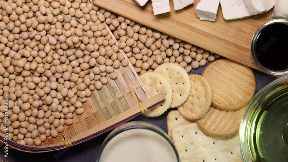 Soyabeans products soya beans flowing bamboo sieve wooden board on jute black stone slate background curd tofu oil milk sauce biscuit cookies Soyabeans products soya beans flowing bamboo sieve wooden board on jute black stone slate background curd tofu oil milk sauce biscuit cookies