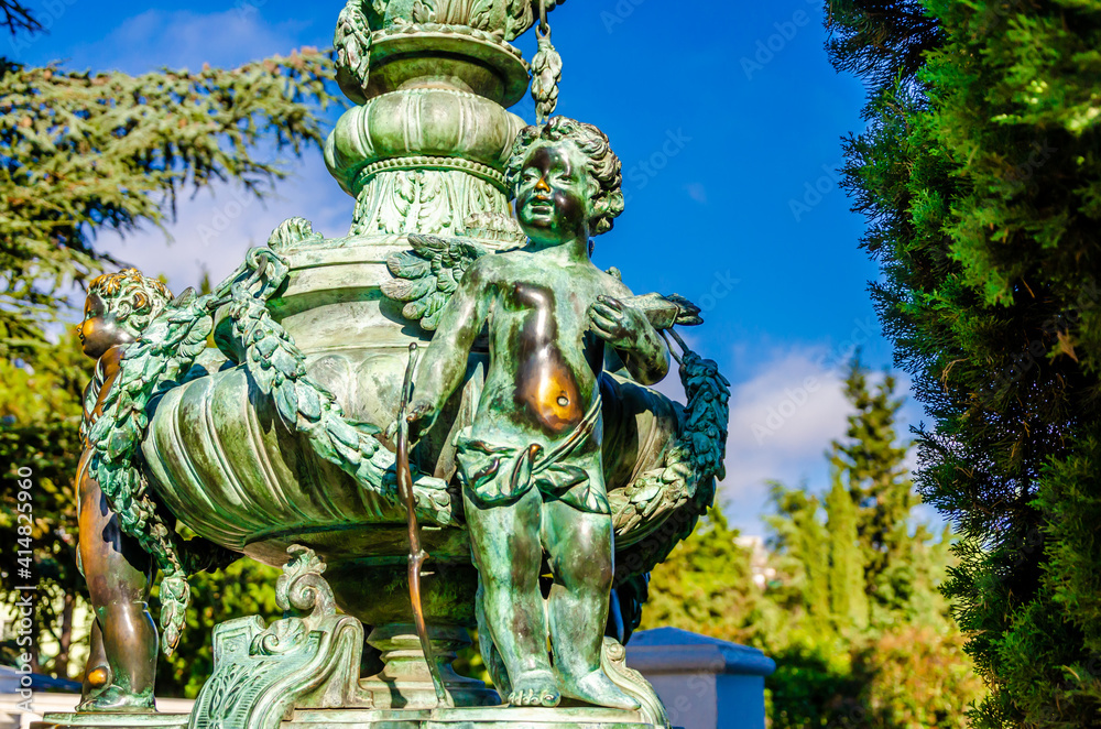 Old bronze figures in the park in summer.