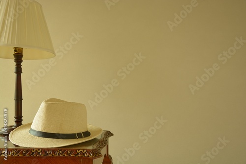 Men's trilby hat.   with mahogany table and mahogany shade lamp. This expensive antique furniture is made in England.   blurred background・soft focus image. photo