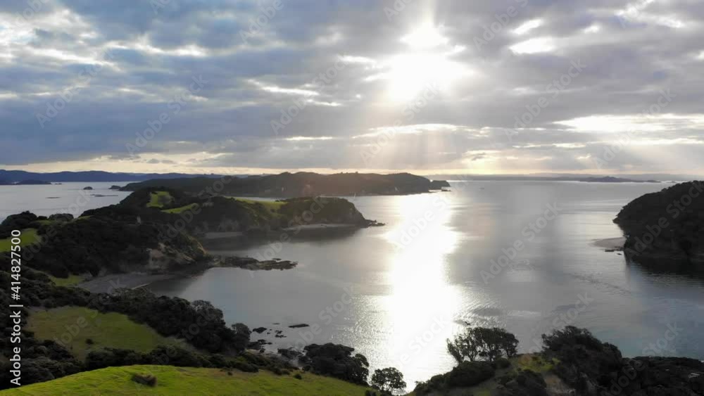 drone flying through Urupukapuka Island in golden hour with a soft direct sunlight ahead drone flying through Urupukapuka Island in golden hour with a soft direct sunlight ahead