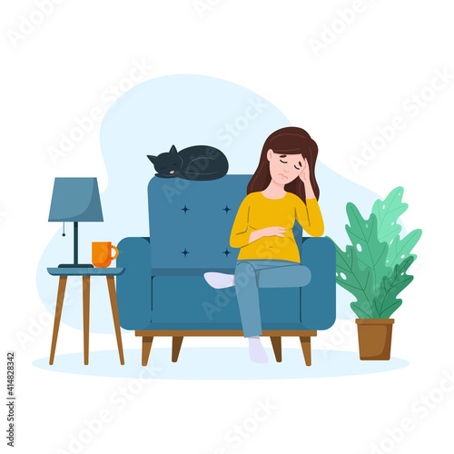 Tired pregnant woman is sitting on the sofa. Heavy pregnancy concept.