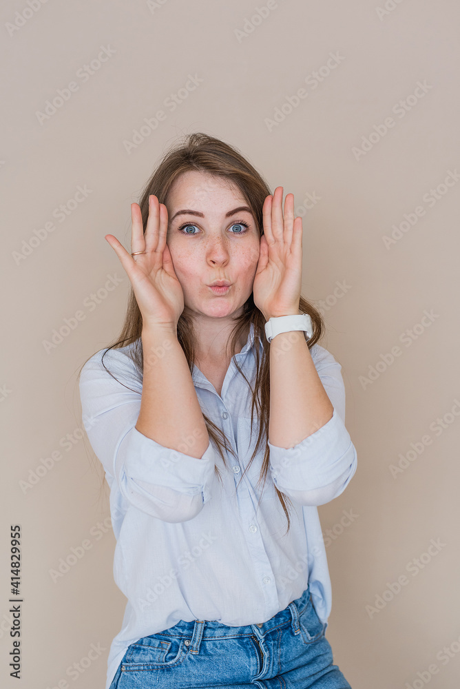 Young girl isolated on beige background playing peekaboo Young girl isolated on beige background playing peekaboo