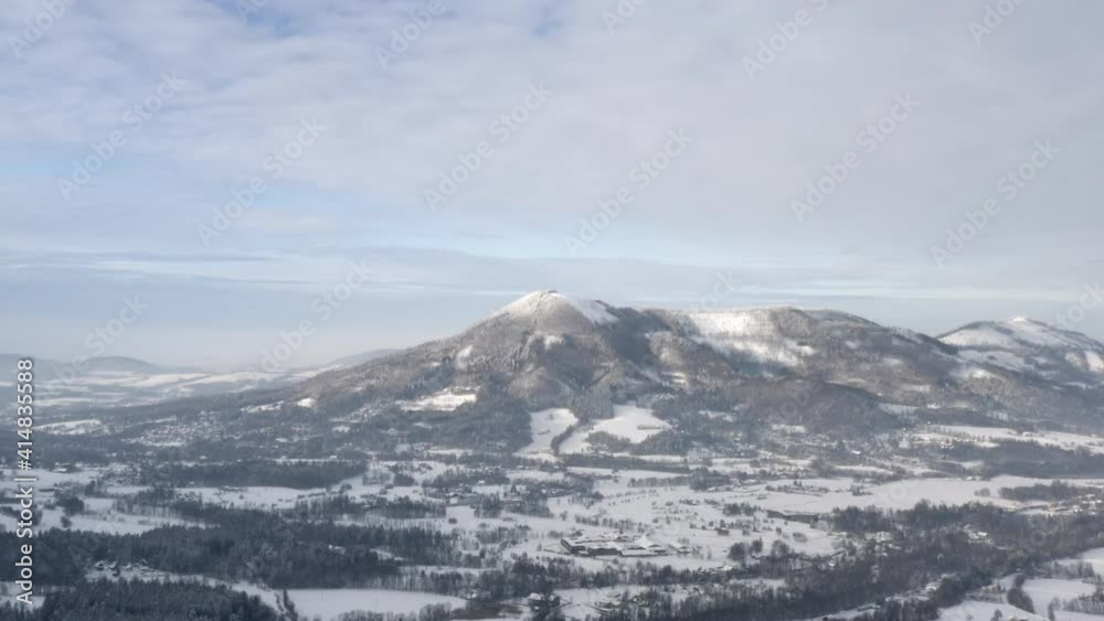 Snow capped mountain range above a forest winter landscape, Czechia. Snow capped mountain range above a forest winter landscape, Czechia.