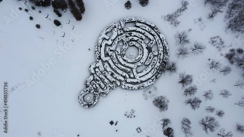 View of a labyrinth as people walk around in winter. photo