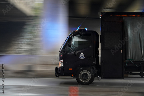 Blue black Royal Malaysia Police truck on a rainy slippery  road