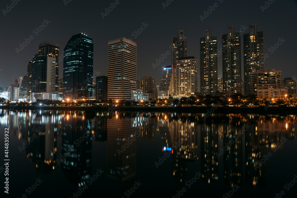Reflection of skyscrapers and condos in pond in Benjakitti Park, Bangkok, Thailand.