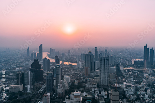 View of Bangkok at sunset from skyscraper, looking down on Chao Praya river.