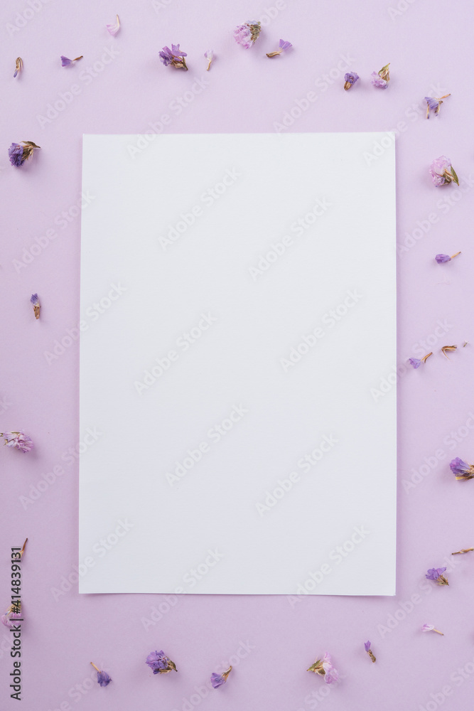 Paper copy space mock up over pastel purple background with lavender flower. Paper copy space mock up over pastel purple background with lavender flower.